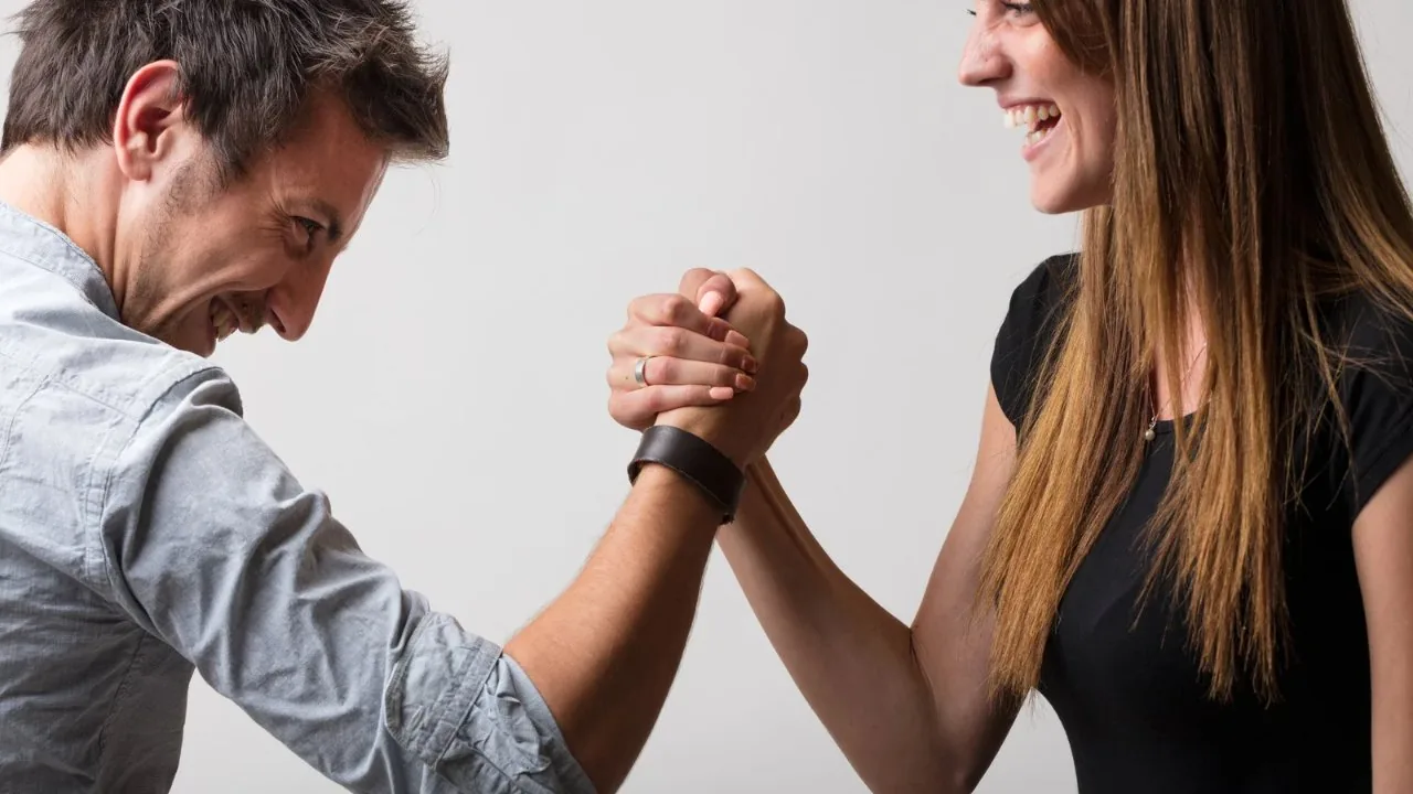 Boyfriend and girlfriend in an arm wrestling game