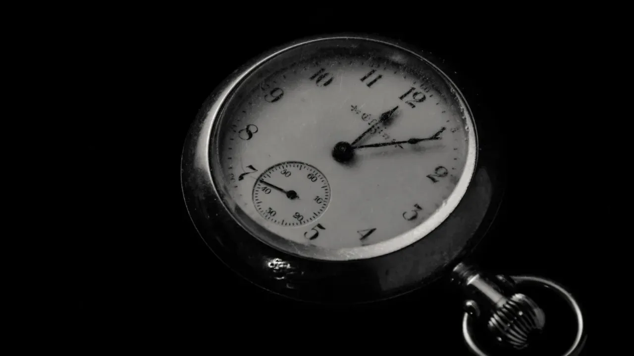 A pocket watch displaying time at 12