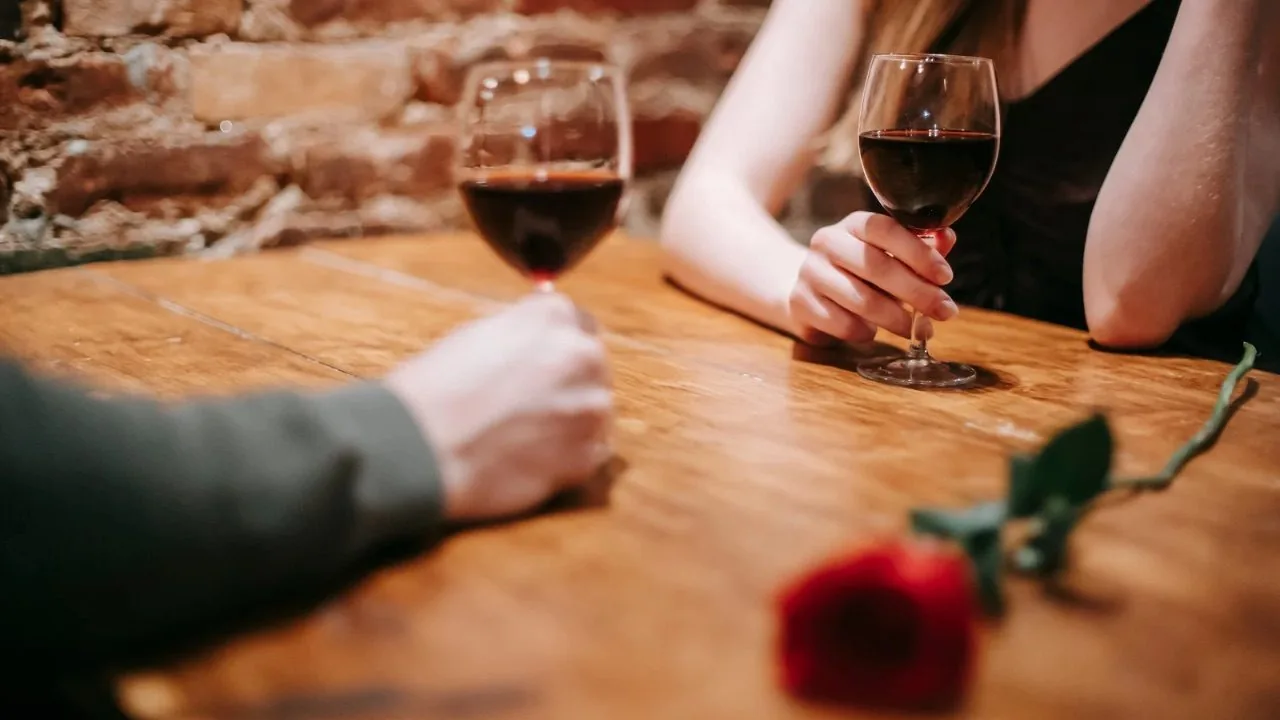 Man and woman holding wine glasses on a table