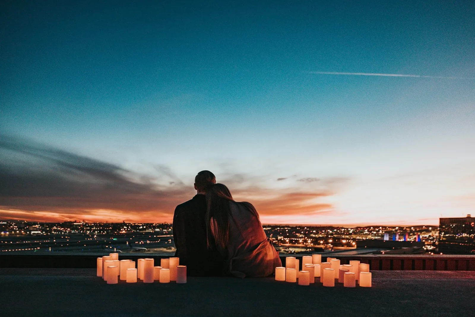 two lovers watching the sunset with candles