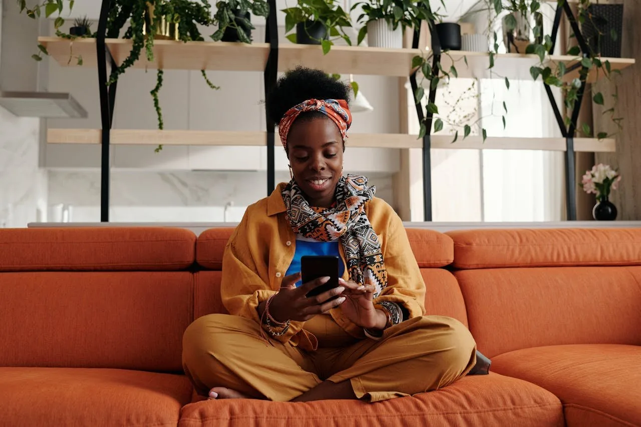 girl sitting on a sofa and texting