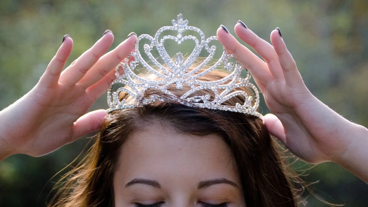 woman placing a crown on her head