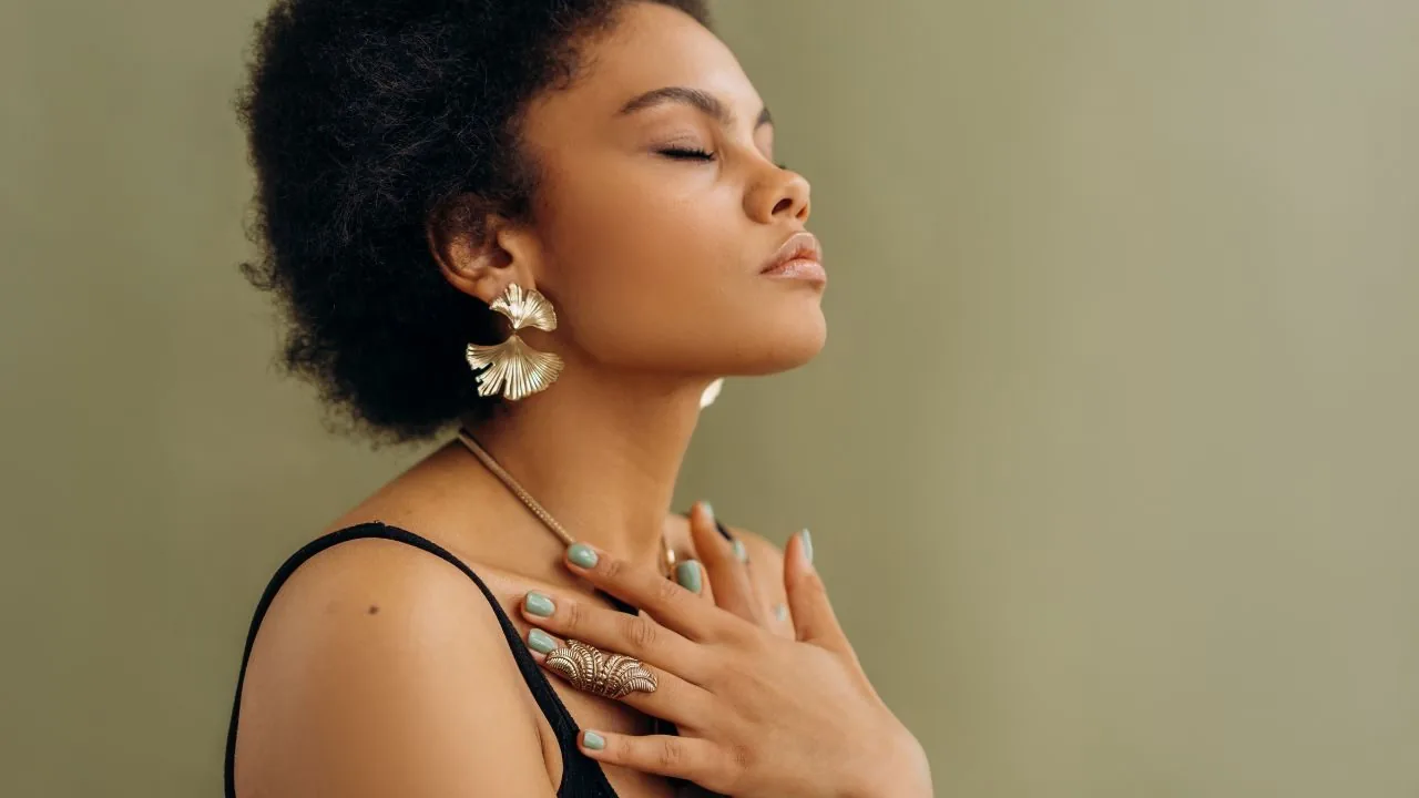 young woman holding her hands to her chest with eyes closed