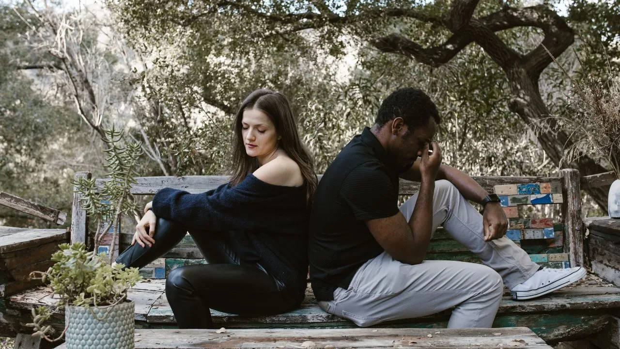  fighting couple sitting with their backs against each other