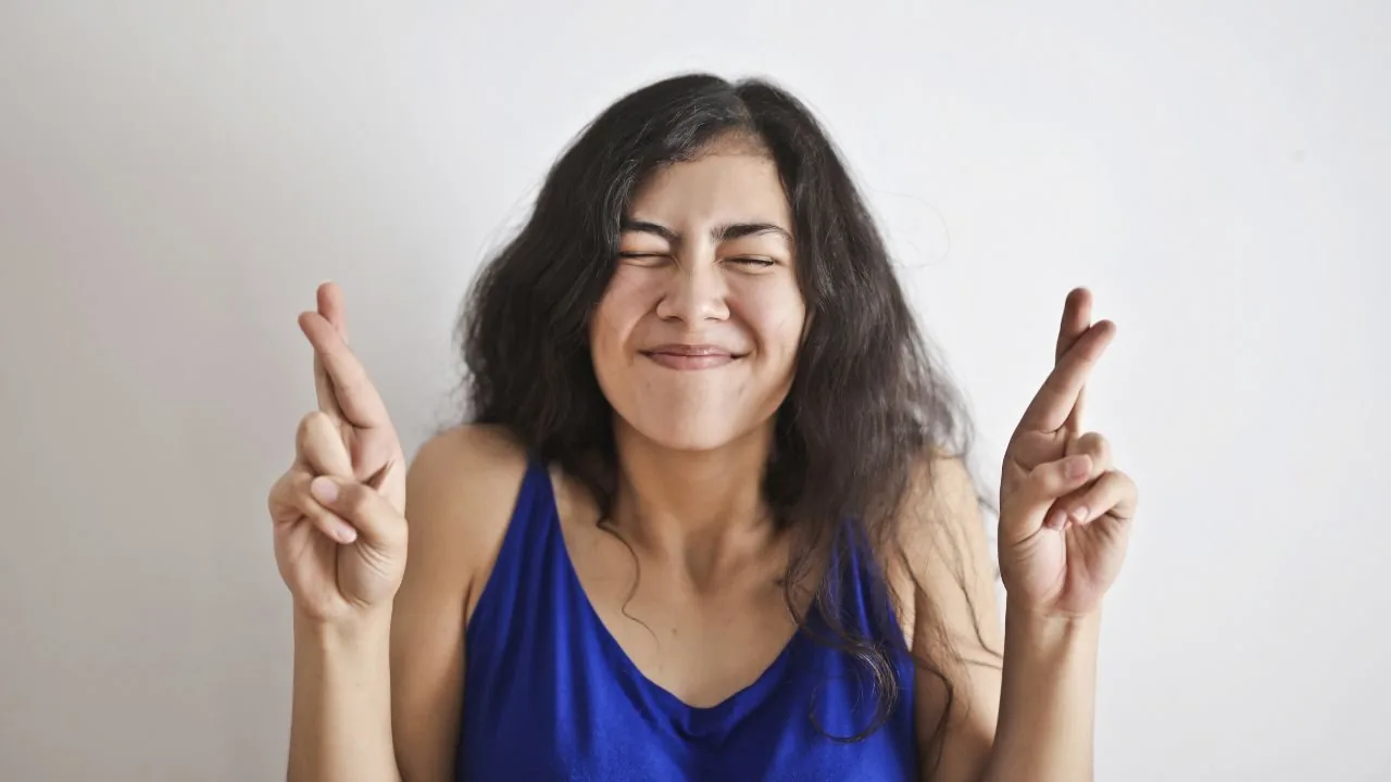 A woman with crossed fingers as a good luck sign